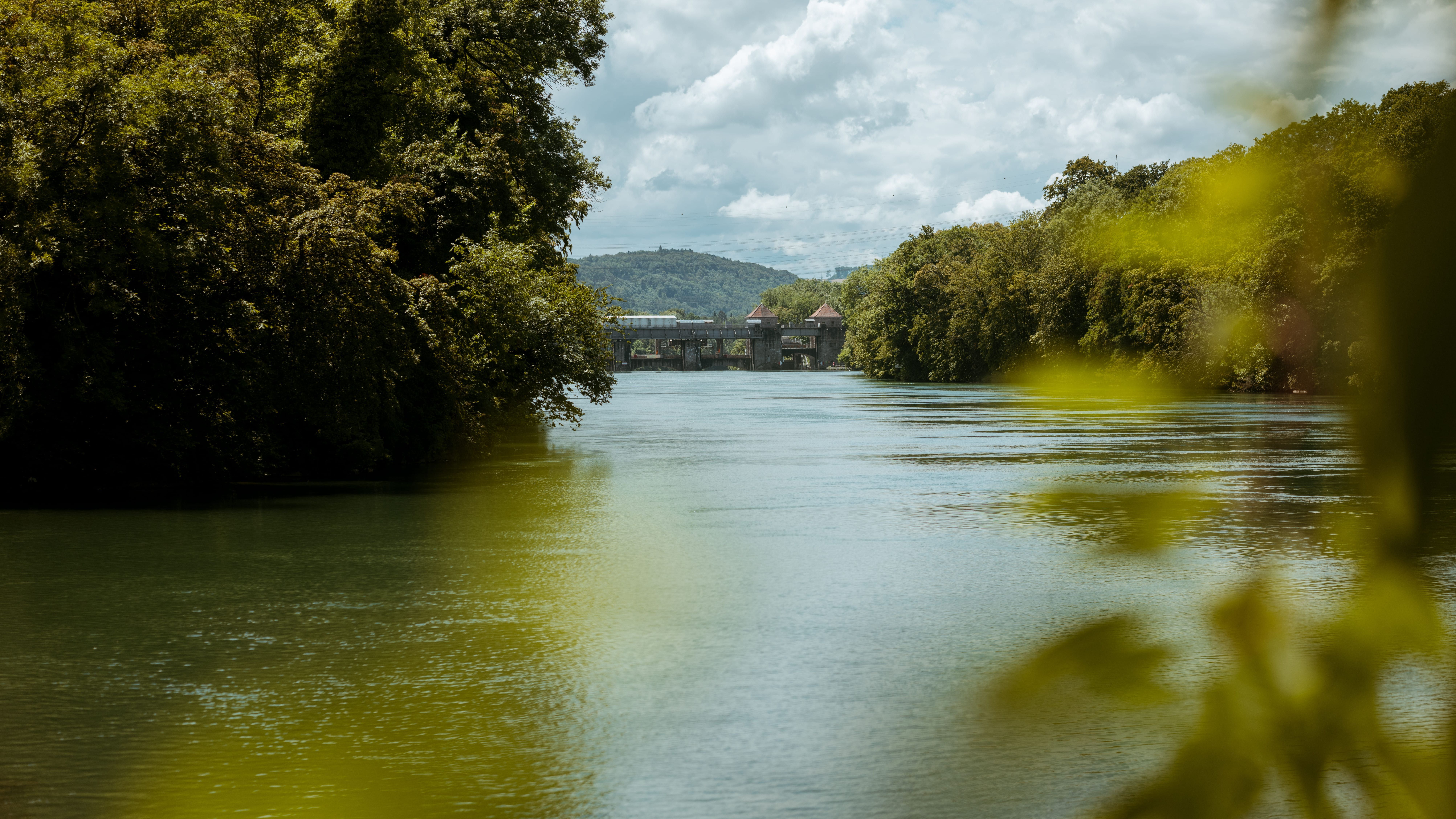 Breiter Fluss mit Brücke im Hintergrund