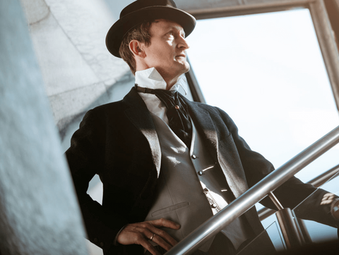 Emil Rathenau Ein elegant gekleideter Mann in einem schwarzen Anzug und Hut geht eine Treppe hinauf.