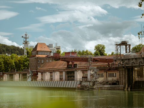 Wasserkraftwerk der naturenergie am Rhein in Laufenburg mit roten Dächern und grüner Umgebung