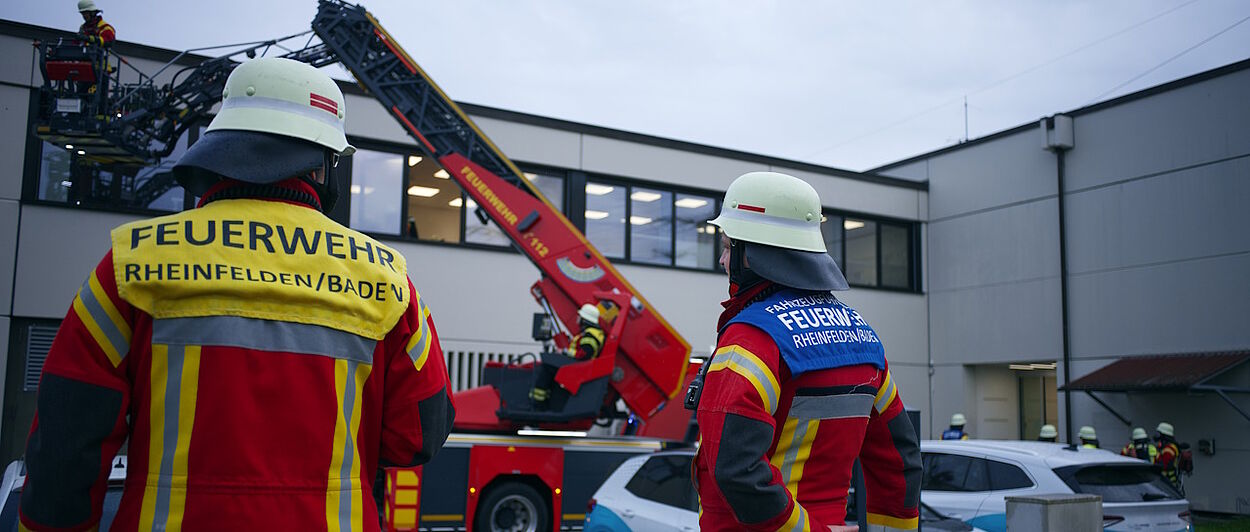 Zwei Feuerwehrmänner vor Gebäude 