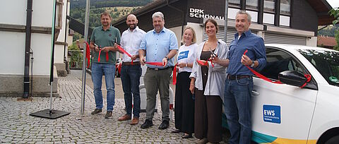 Sechs Personen an einer Elektro-Ladestation