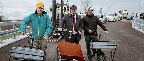 Drei Personen mit Fahrrädern