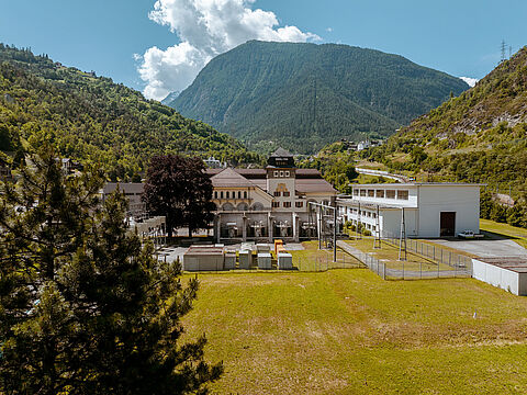 Gebäudekomplex in alpiner Landschaft Kraftwerk vor grünem Bergpanorama mit Industrieelementen